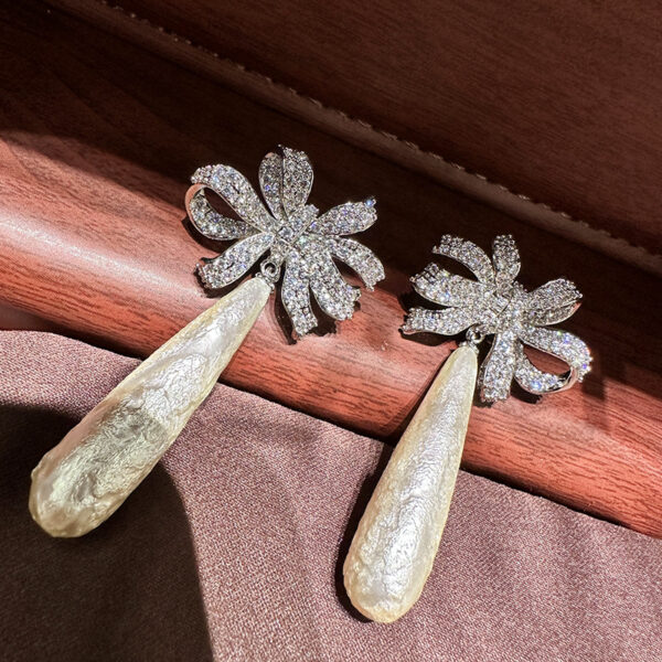 #77 The new retro long pearl bow diamond-encrusted earrings from Europe and America feature a noble, elegant and fashionable style. The ribbon earrings are exaggerated and personalized